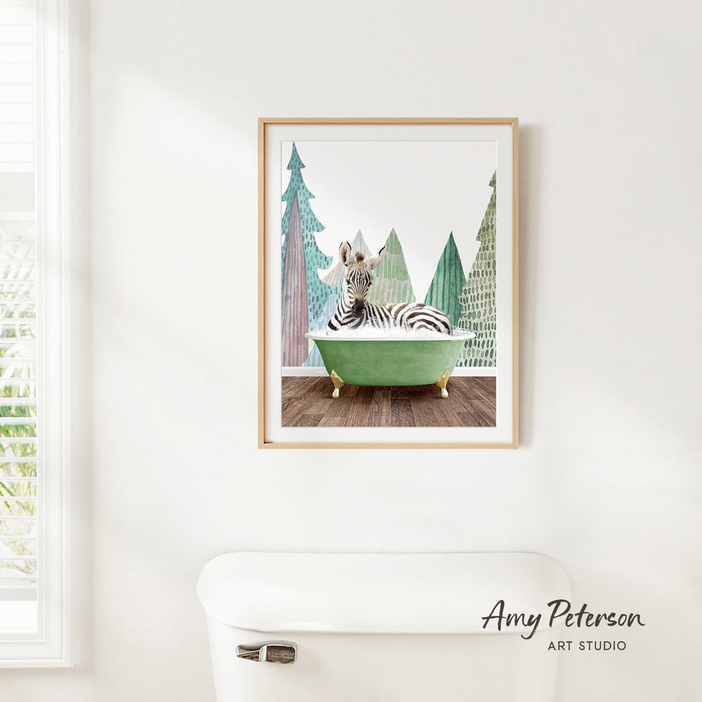 A framed print of a zebra sitting in a green bathtub, surrounded by trees, is hanging on a white wall.