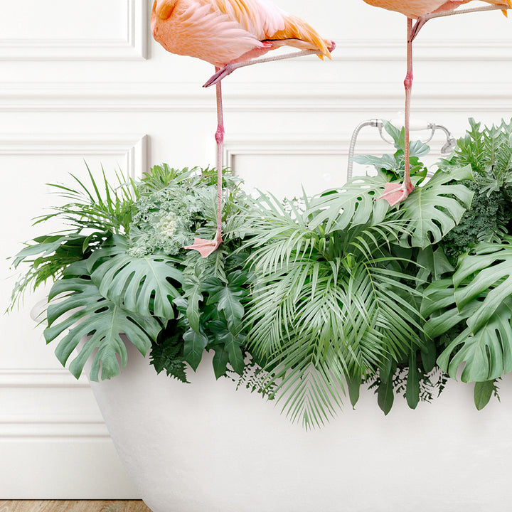 two pink flamingos standing on top of a planter