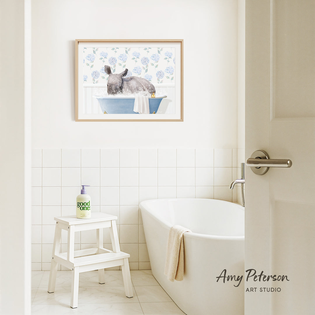 A bathroom interior with a white bathtub, a stool, and a framed painting of a rabbit in a bathtub on the wall.
