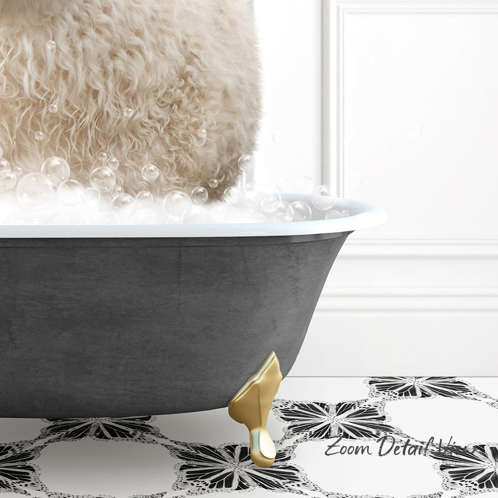 A fluffy white dog is standing in a bathtub filled with bubbles, with a gold claw-like object on the floor.