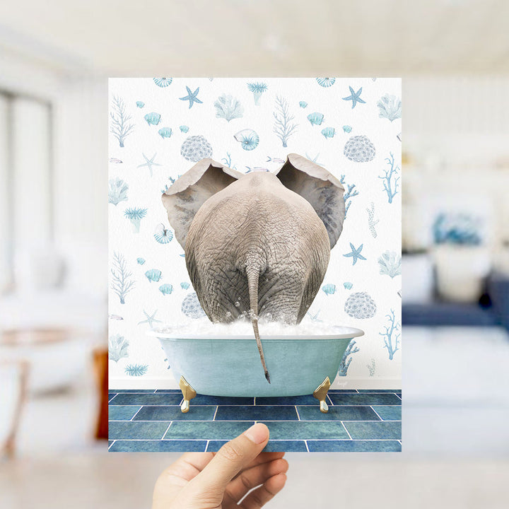 A hand is holding up a collage of images featuring an elephant sitting in a bathtub filled with bubbles, surrounded by a blue and white ocean-themed background.