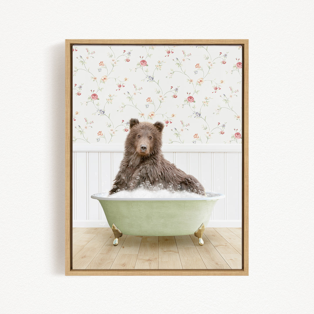 A brown bear sitting in a green bathtub filled with bubbles, with a floral wallpaper in the background.