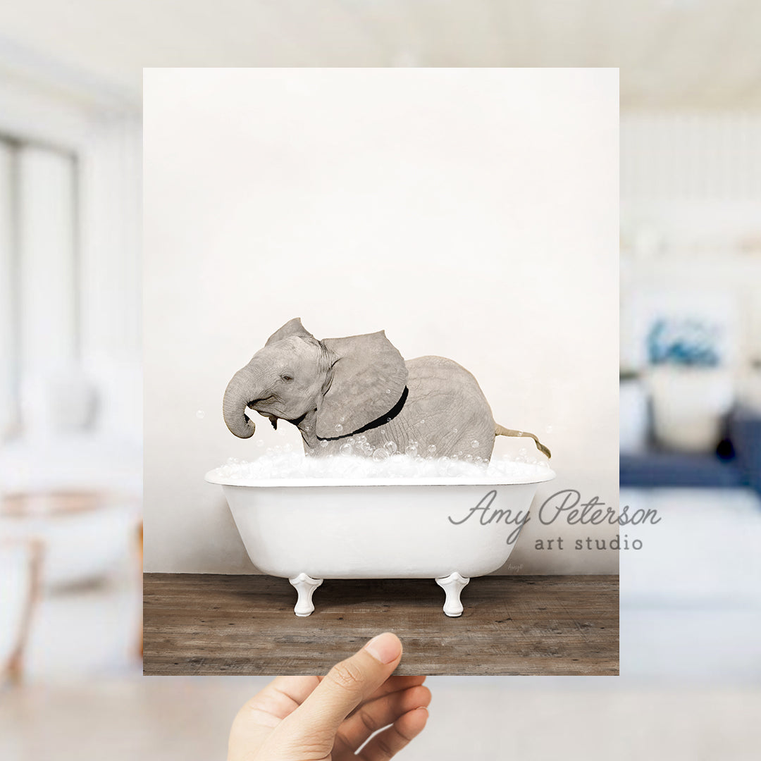 a person holding up a picture of an elephant in a bathtub