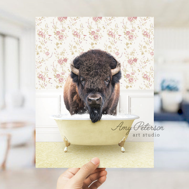 a person holding up a picture of a bison in a bathtub