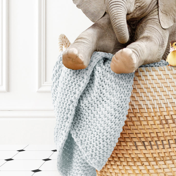 a stuffed elephant sitting on top of a basket