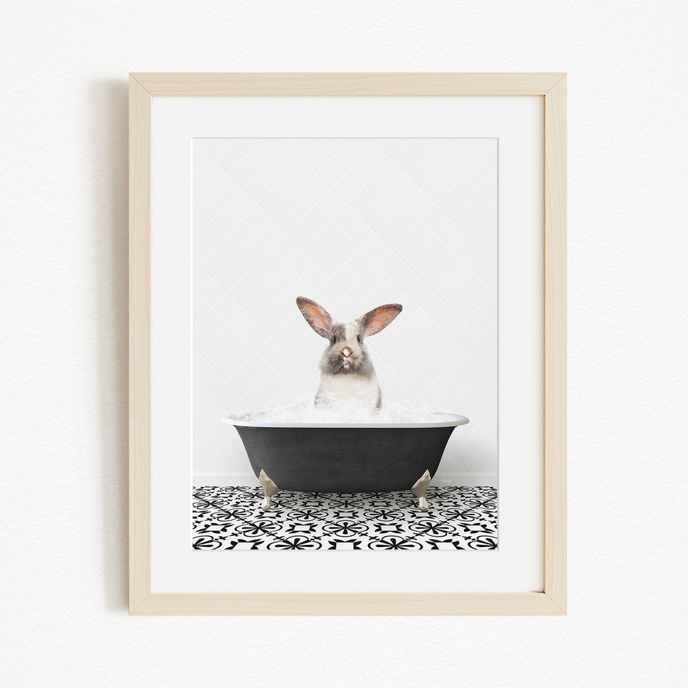 A white rabbit sitting in a black bathtub filled with water, with its head above the water level.
