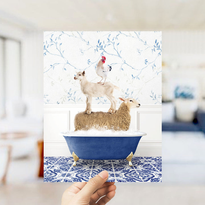 A hand holds up a framed image depicting a sheep standing on a bathtub filled with water, with a chicken perched on top.