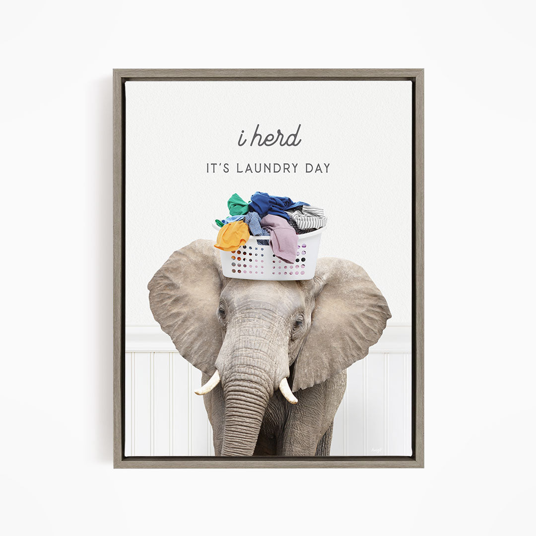 A gray elephant holding a basket of clothes on its head, with the text "It's Laundry Day" above it.