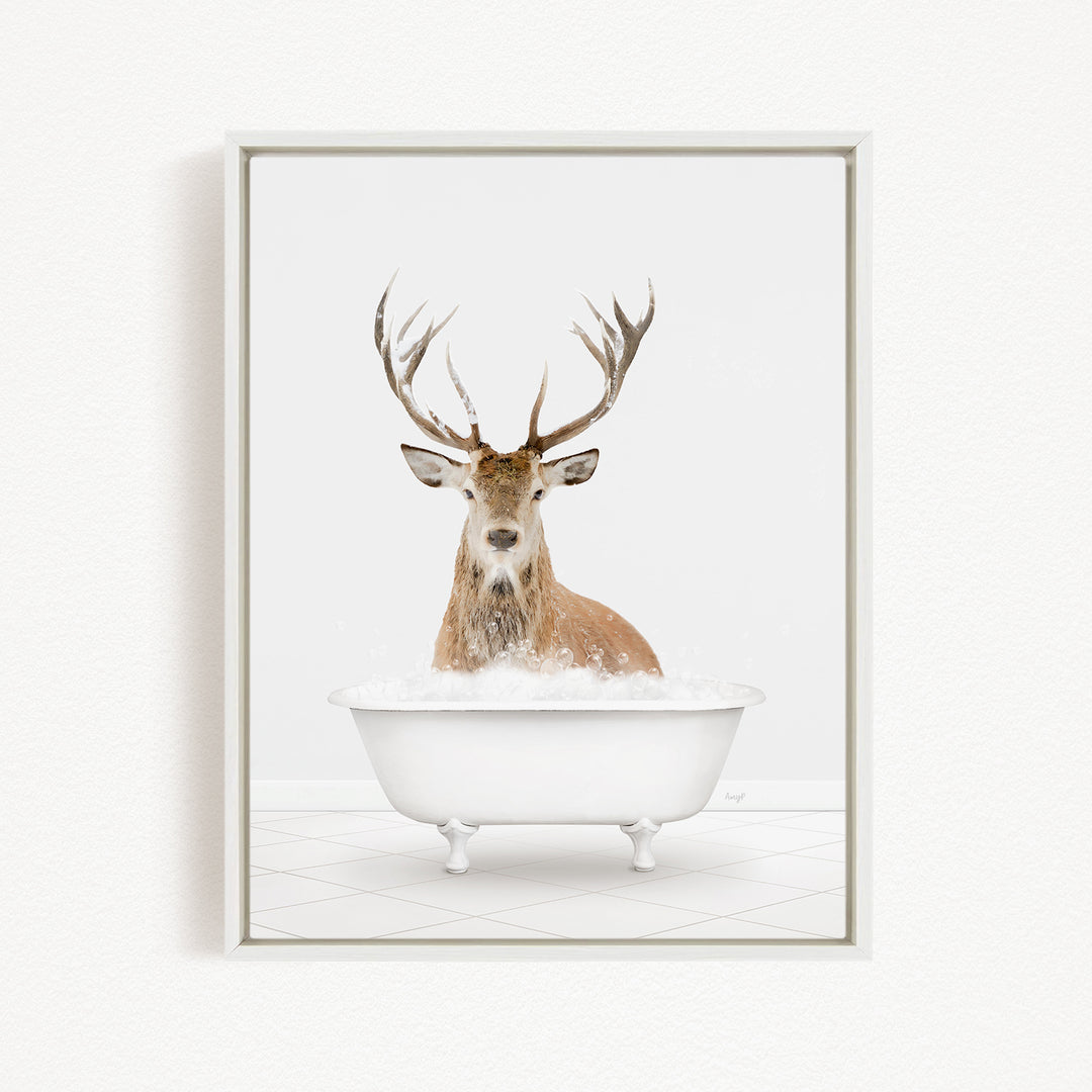 A deer with large antlers is sitting in a white bathtub filled with water, creating a whimsical and unexpected scene.
