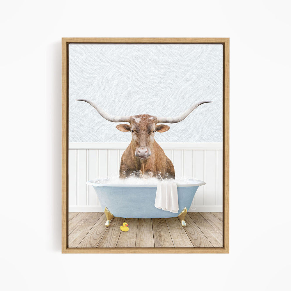 A brown bull with long horns is sitting in a blue bathtub filled with water, surrounded by rubber ducks.