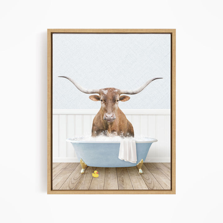A brown bull with long horns is sitting in a blue bathtub filled with water, surrounded by rubber ducks.