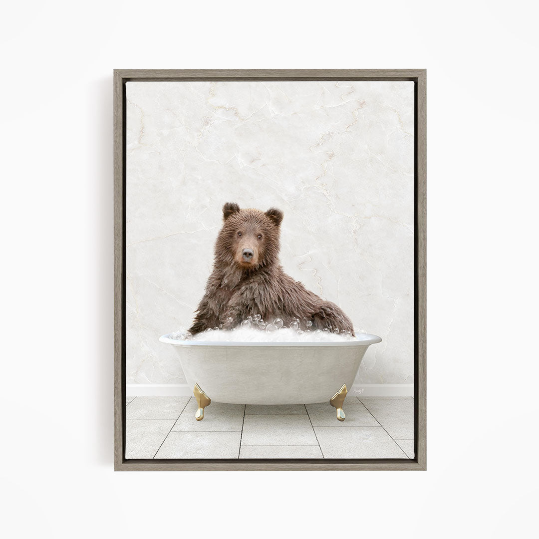 A brown bear sitting in a white bathtub filled with water, looking directly at the camera.