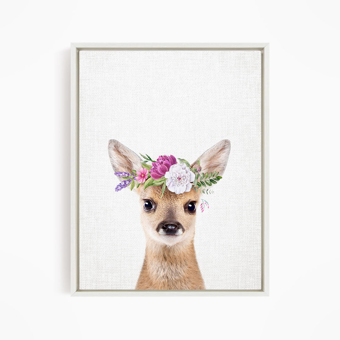 A deer wearing a floral crown on its head.