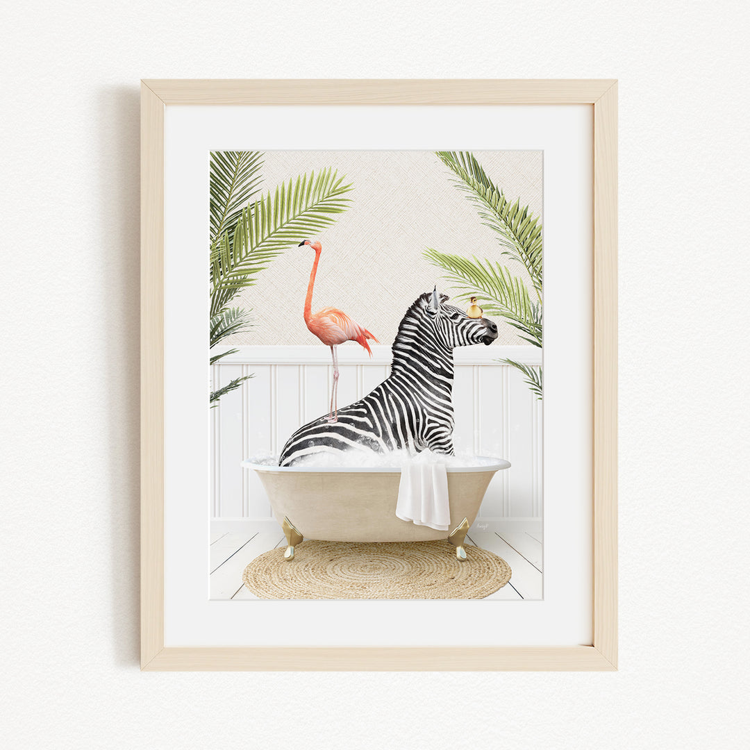 A framed image depicting a zebra sitting in a bathtub, surrounded by a pink flamingo and tropical plants.