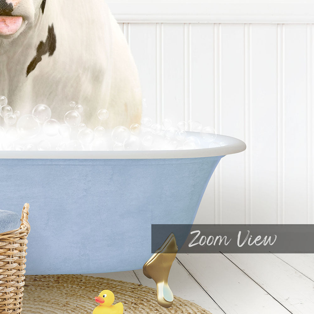 A white cow is standing in a blue bathtub filled with bubbles, with a yellow rubber duck nearby.