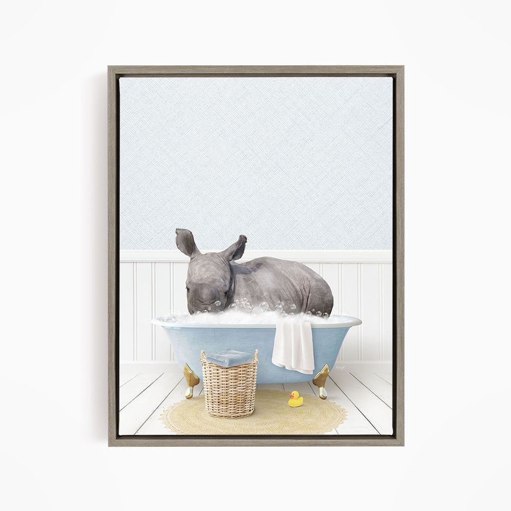 A rhinoceros is sitting in a blue bathtub filled with water, surrounded by a yellow rubber duck and a basket.