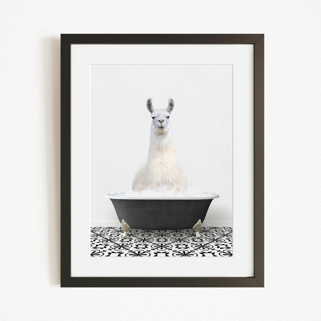 A white llama sitting in a black bathtub filled with water, surrounded by a black and white patterned tile floor.