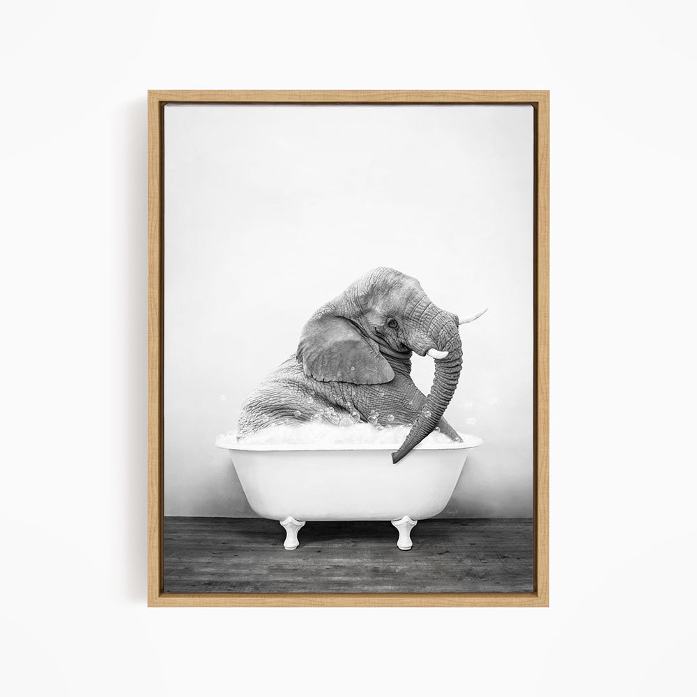A black and white photograph of an elephant sitting in a bathtub filled with water.
