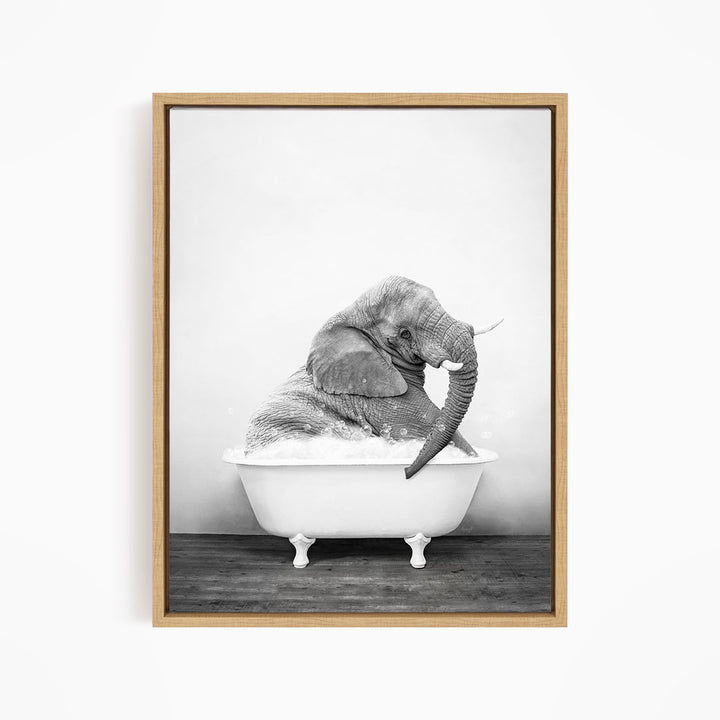A black and white photograph of an elephant sitting in a bathtub filled with water.