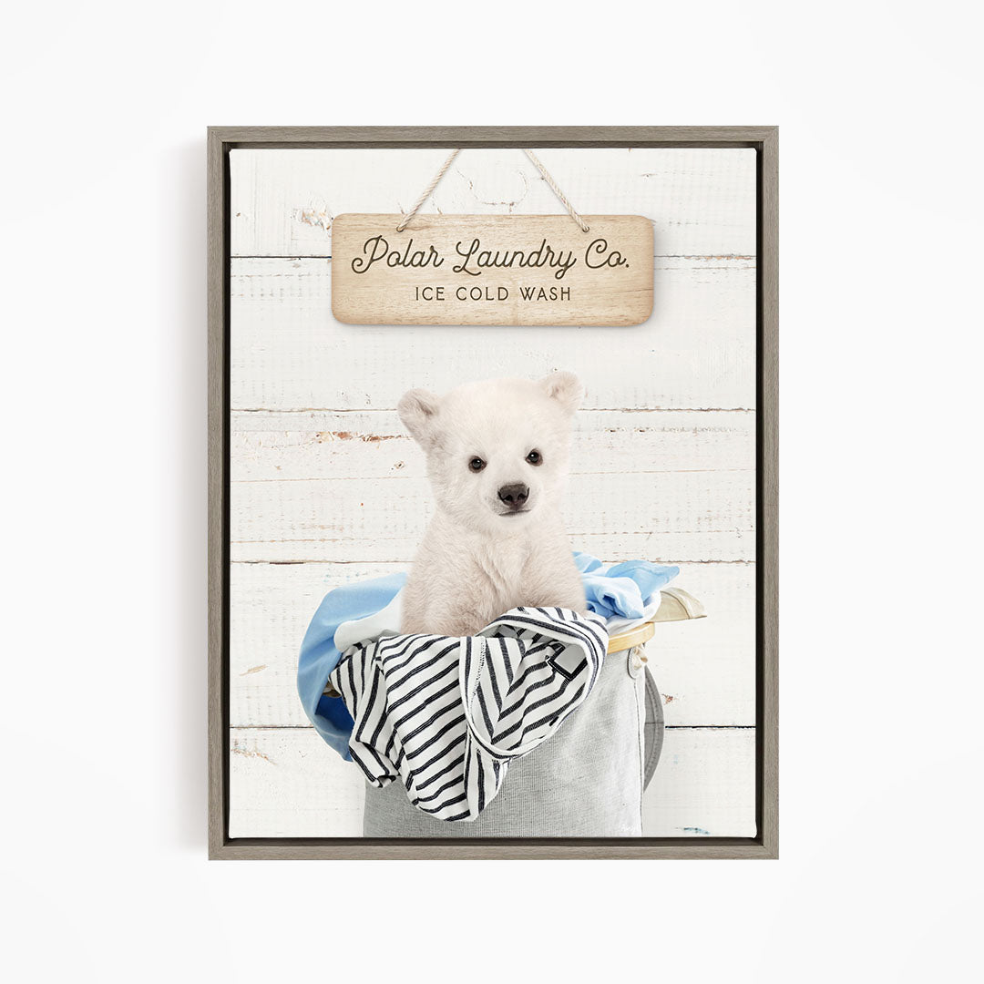 A cute white polar bear sitting in a laundry basket, with a wooden sign above that reads "Polar Laundry Co. Ice Cold Wash".