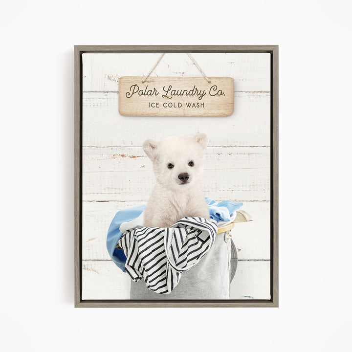 A cute white polar bear sitting in a laundry basket, with a wooden sign above that reads "Polar Laundry Co. Ice Cold Wash".