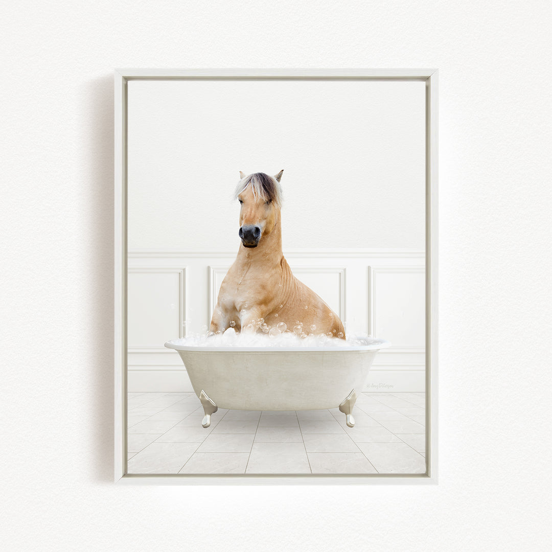 A light brown horse is sitting in a white bathtub filled with bubbles, creating a whimsical and playful scene.