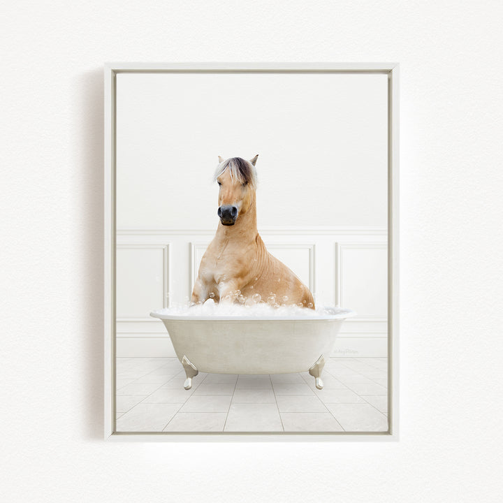 A light brown horse is sitting in a white bathtub filled with bubbles, creating a whimsical and playful scene.