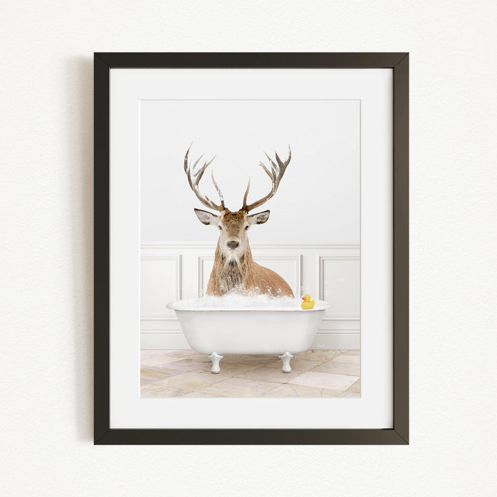 A deer with large antlers is sitting in a white bathtub filled with water, with a yellow rubber duck floating in the tub.