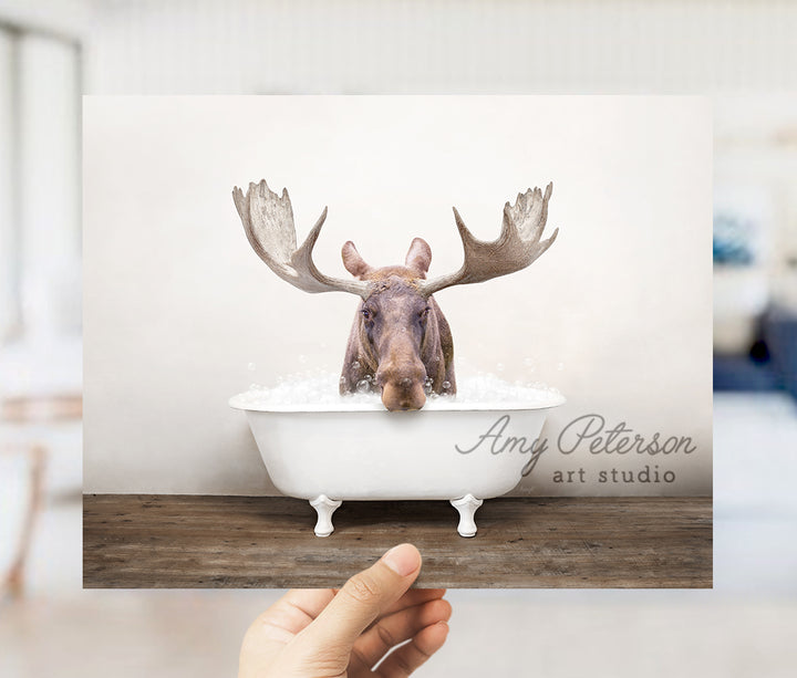 a person holding up a card with a picture of a moose in a bathtub