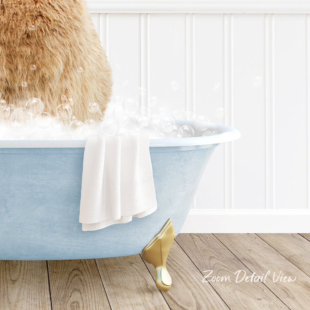 A fluffy brown cat is sitting in a blue bathtub filled with bubbles, with a white towel and gold bathtub leg visible.