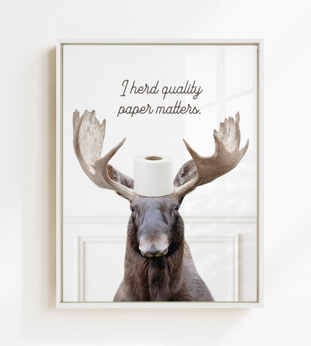 A moose wearing a toilet paper roll on its head, with the text "I herd quality paper matters" above it.
