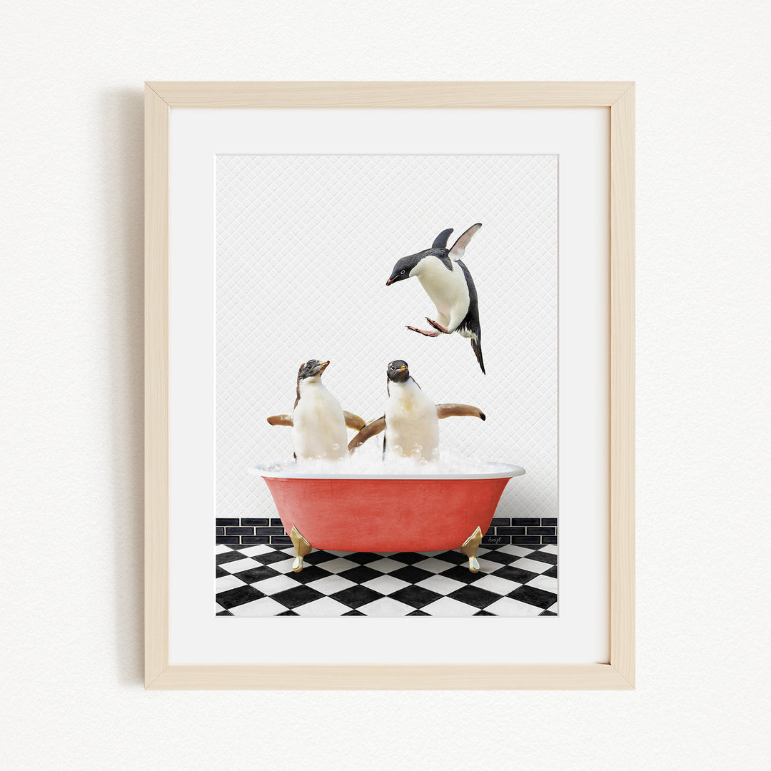 A framed image depicting two penguins sitting in a red bathtub, with one penguin flying towards the other.