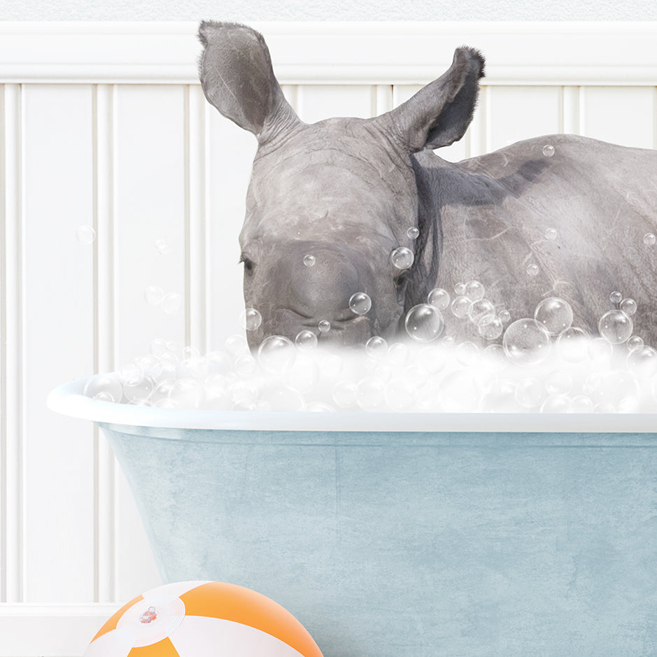 a rhino in a bathtub with bubbles and a beach ball