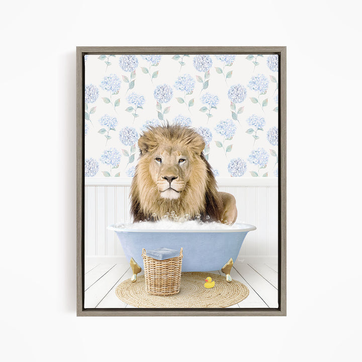 A lion is sitting in a blue bathtub filled with water, surrounded by a wicker basket and yellow rubber ducks.
