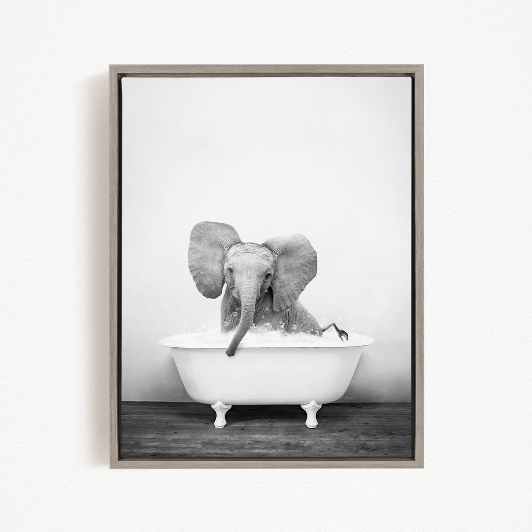 A baby elephant sitting in a white bathtub filled with water, appearing to enjoy the bath.