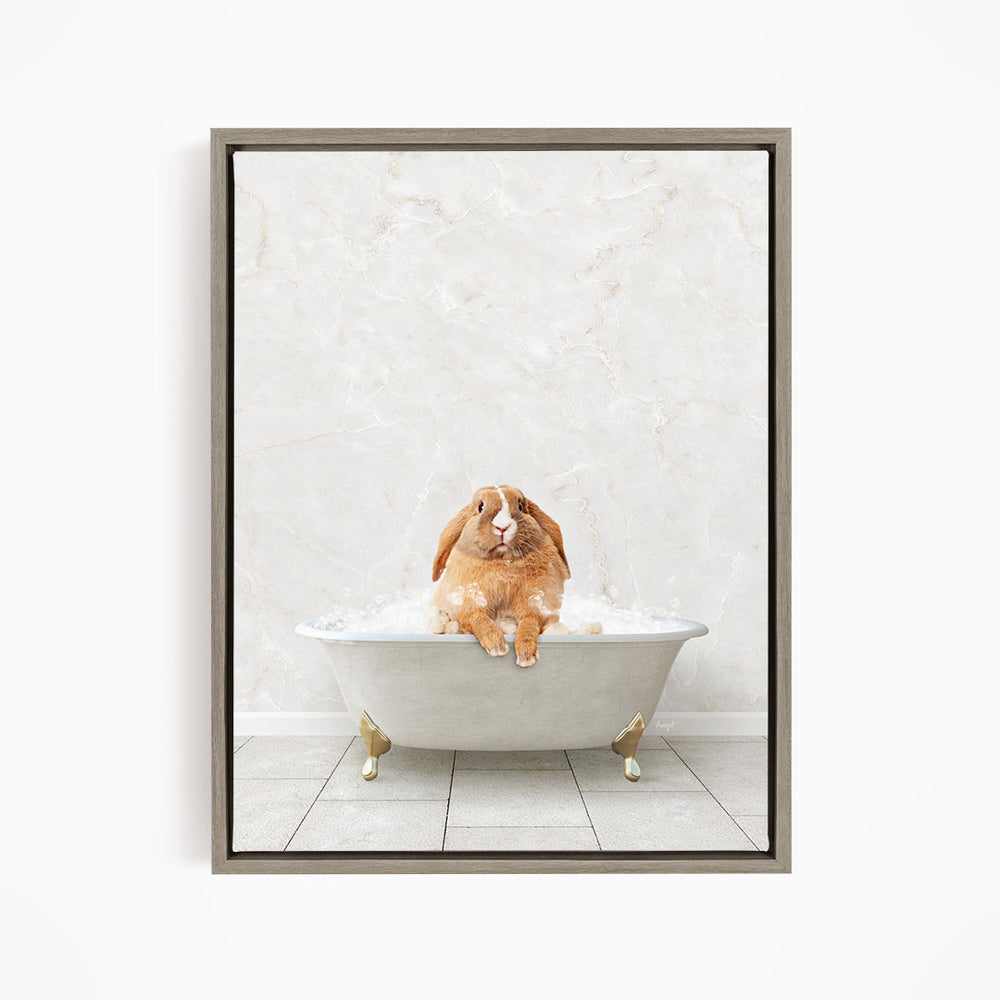 A brown rabbit sitting in a white bathtub filled with bubbles, looking up at the camera.