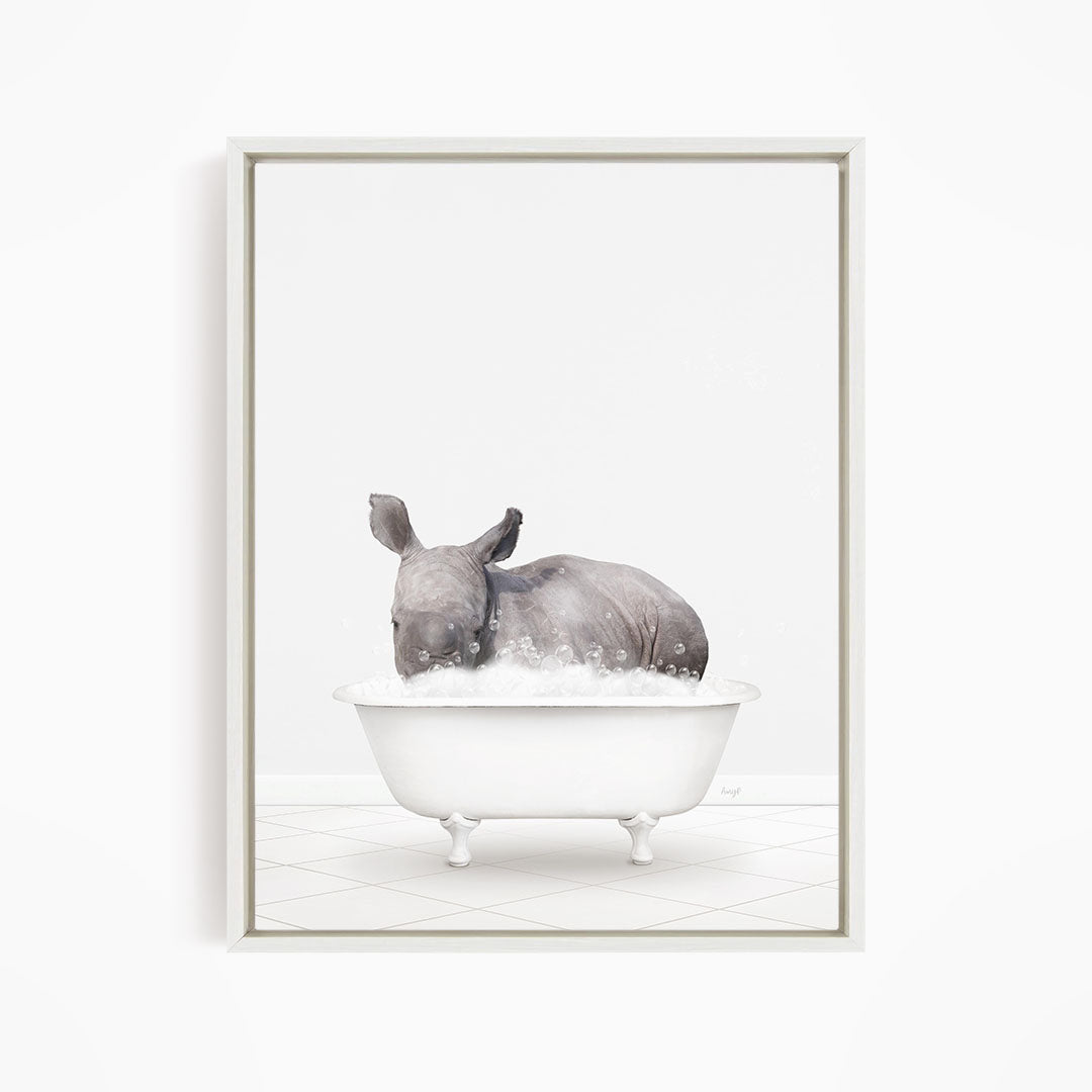 A rhinoceros is sitting in a white bathtub filled with water, creating a whimsical and playful scene.