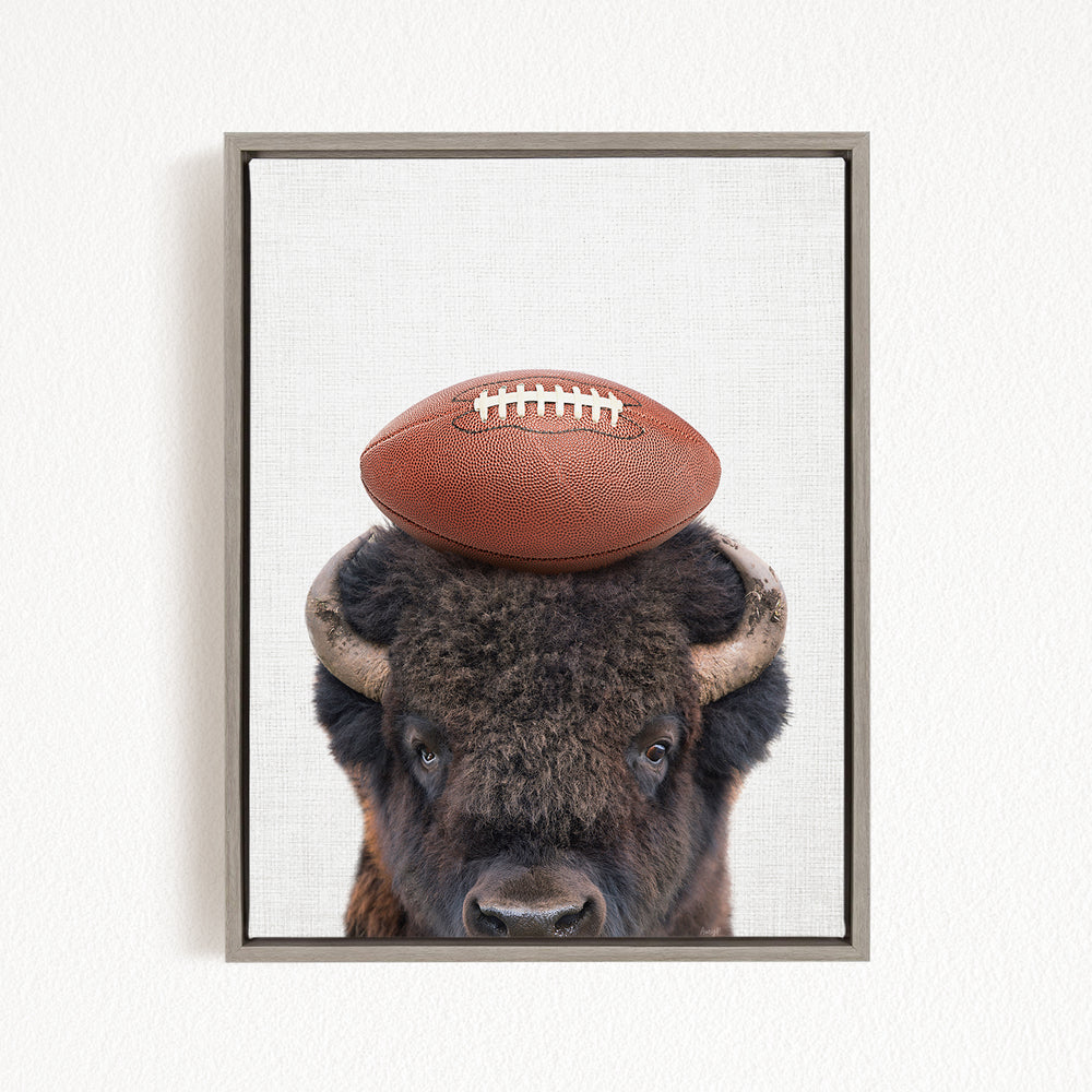 A buffalo with a football resting on its head.