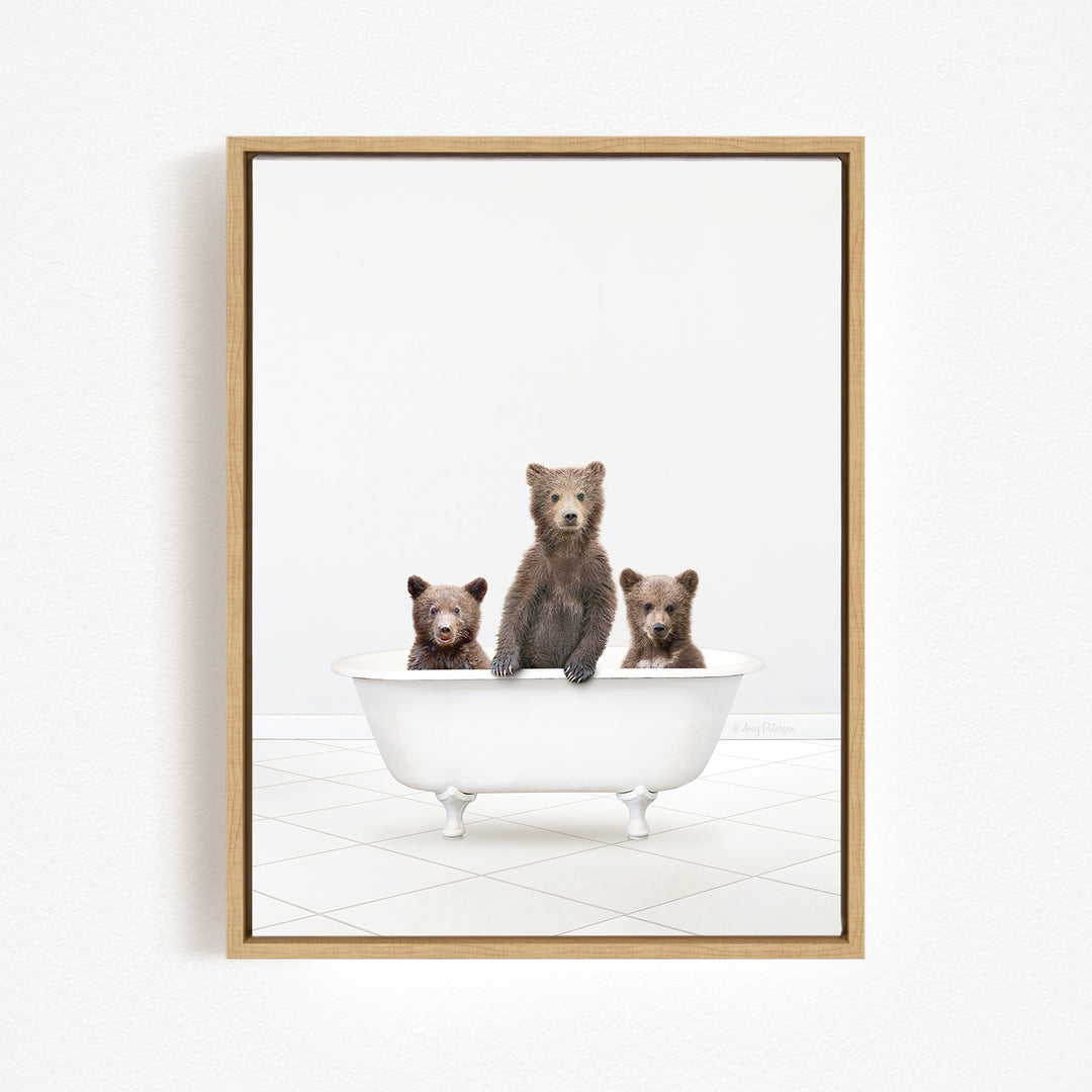 Three brown bears sitting in a white bathtub against a white background.
