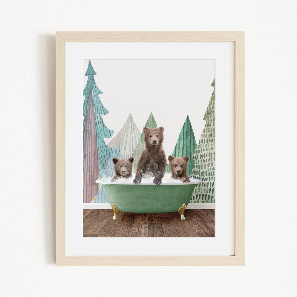 A framed print depicting three bears sitting in a green bathtub, with a forest scene in the background.