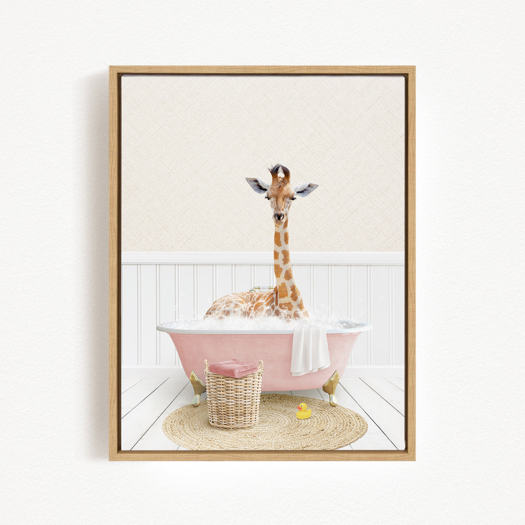 A giraffe is sitting in a pink bathtub filled with bubbles, surrounded by a basket of toys and a yellow rubber duck.