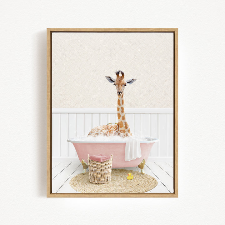 A giraffe is sitting in a pink bathtub filled with bubbles, surrounded by a basket of toys and a yellow rubber duck.