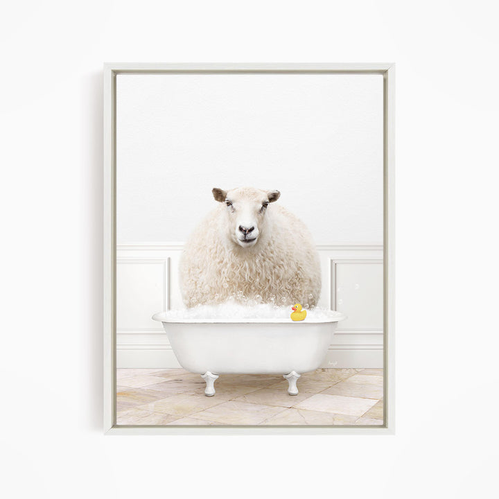 A fluffy white sheep sits in a white bathtub filled with bubbles, with a yellow rubber duck floating in the water.