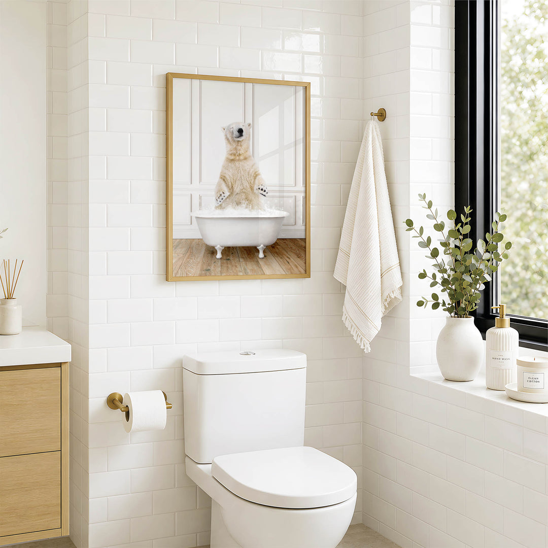A bathroom with a white toilet, a framed image of a polar bear sitting in a bathtub, and a window with greenery on the sill.