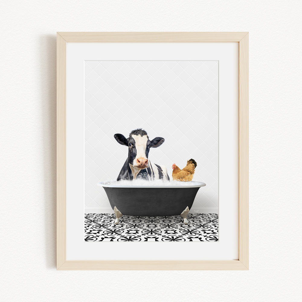 A framed image depicting a cow and a chicken relaxing together in a bathtub.