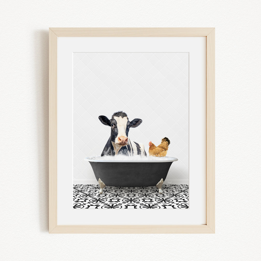 A framed image depicting a cow and a chicken relaxing together in a bathtub.