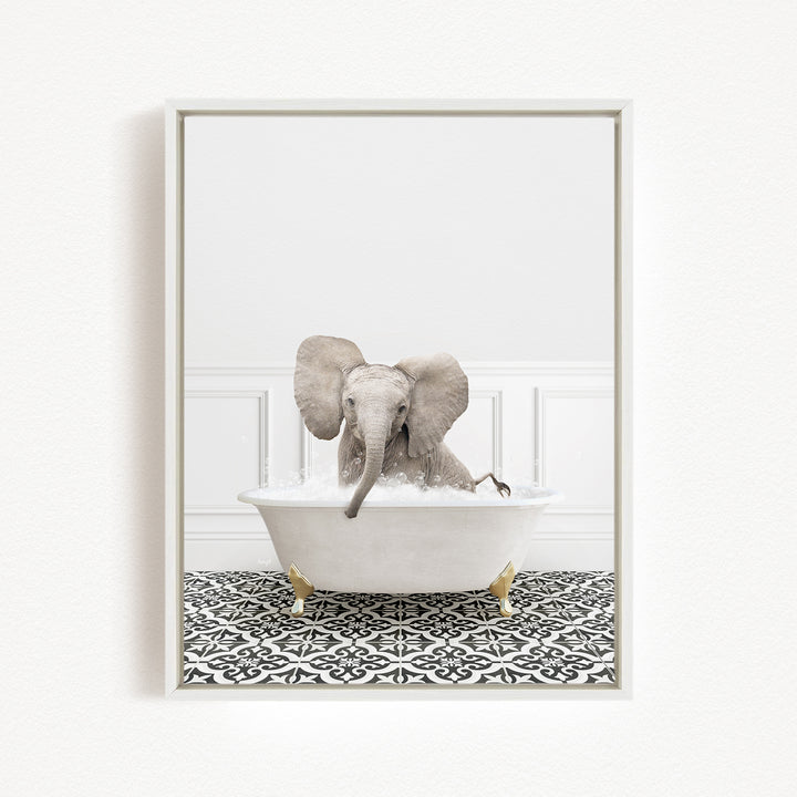 A baby elephant sitting in a white bathtub filled with water, surrounded by a black and white patterned floor.