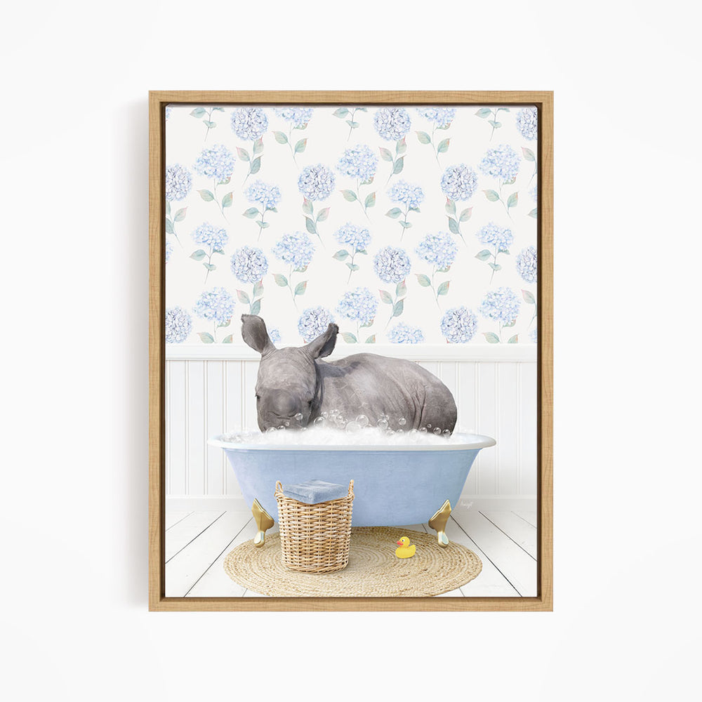 A rhinoceros is sitting in a blue bathtub filled with water, surrounded by a wicker basket and yellow rubber ducks.