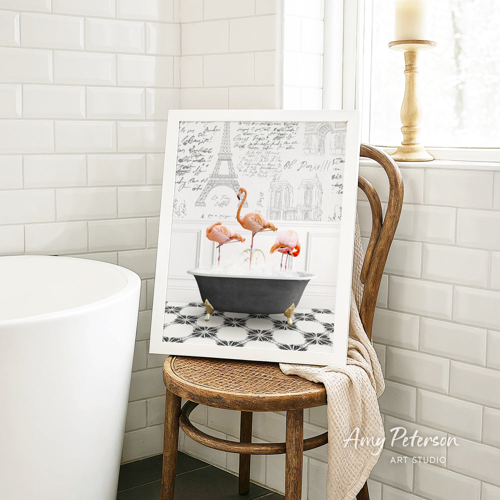A framed image of three flamingos sitting in a bathtub, with a tiled wall and a window in the background.