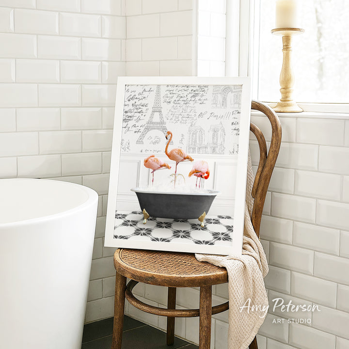 A framed image of three flamingos sitting in a bathtub, with a tiled wall and a window in the background.